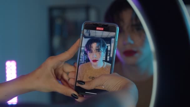 Makijaż studio - artystka fotografująca swojego modela z makijażem w neonowym oświetleniu - odważny wygląd z czerwonymi ustami i mokrymi włosami — Wideo stockowe