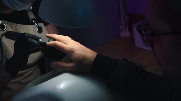 Nagel meester reinigt de nagel uit nagelriemen met behulp van een kleine nagel slijper op mannelijke handen — Stockvideo