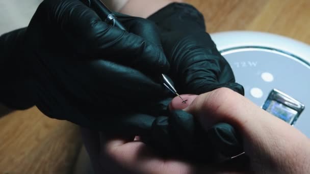 Manicure - mestre que desenha umas cruzes com um esmalte de prego preto — Vídeo de Stock