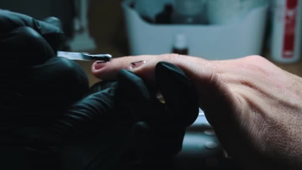 Manikűr - mester alkalmazása egy felső réteg tiszta körömlakk tetején a fekete design - férfi manikűr — Stock videók
