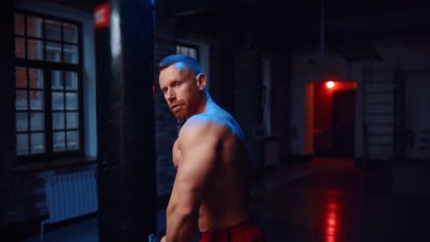 Homem forte de pé no ginásio e mostrando seus grandes músculos — Vídeo de Stock