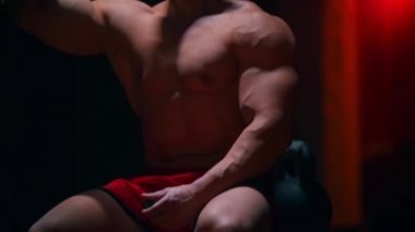 Kendine güveni tam bir adam spor salonundaki kırmızı ışıkla temiz su içiyor.