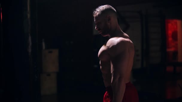 Homem forte bombeando seus bíceps com halteres — Vídeo de Stock