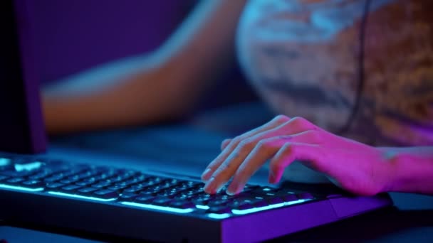 Dövmeli oyuncu kız sakız çiğniyor ve bilgisayarın yanında oturuyor. — Stok video