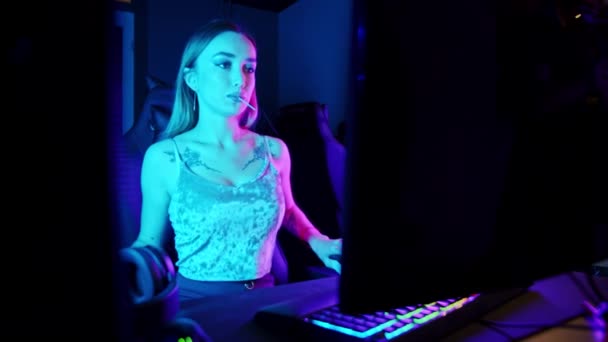 Sexy joven sentada junto al PC y preparándose para la sesión de juego en línea — Vídeos de Stock