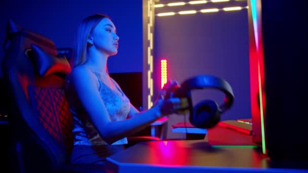 Sexy jeune femme assise dans le club de jeu et de mettre de gros écouteurs — Video