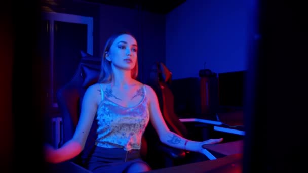 Sexy tatoué jeune femme assise dans le club de jeu - mettre des écouteurs — Video