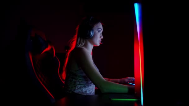 Getatoeëerde jonge vrouw zitten in neon gaming club - het spelen van spel en raakt opgewonden — Stockvideo