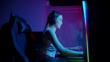 Neon oyun kulübünde oynayan dövmeli seksi genç kadın.