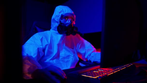 Чоловік в медичному захисному костюмі і чорний респіратор грає в ігровому клубі — стокове відео