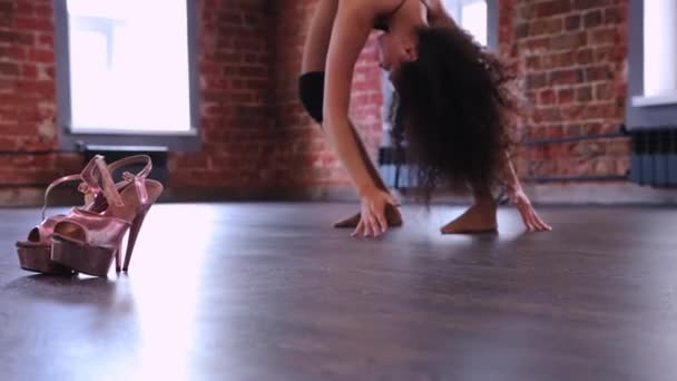 Mujer joven bailarina calentando su cuerpo antes de bailar - tacones altos cerca de ella — Vídeo de stock
