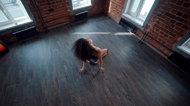 어두운 바닥에서 젊은 여자가 하이힐을 신고 바닥에서 춤을 추는 모습 이 스튜디오 안에서 펼쳐지고 있다 — 비디오