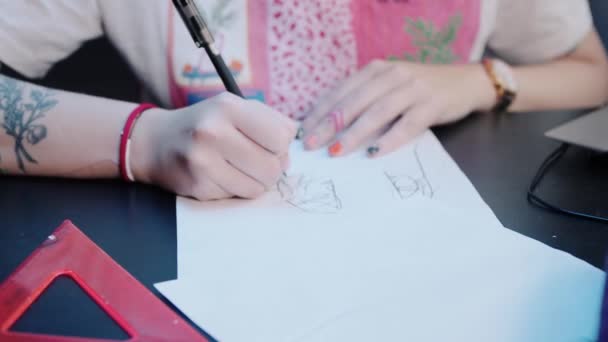 Joven mujer tatuaje maestro dibuja boceto para tatuaje en el estudio — Vídeo de stock