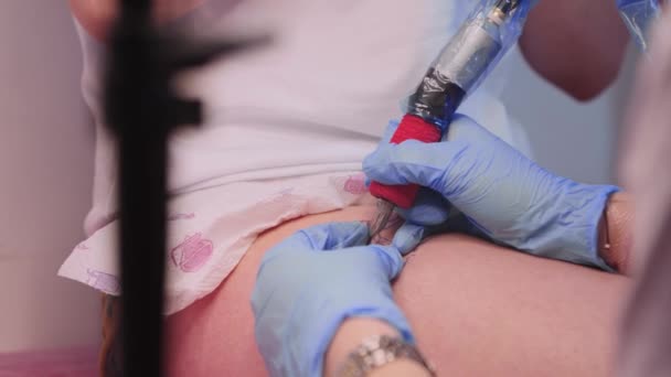 Sesja tatuażowa - mistrz tatuażu rysujący kontury na nodze klienta — Wideo stockowe