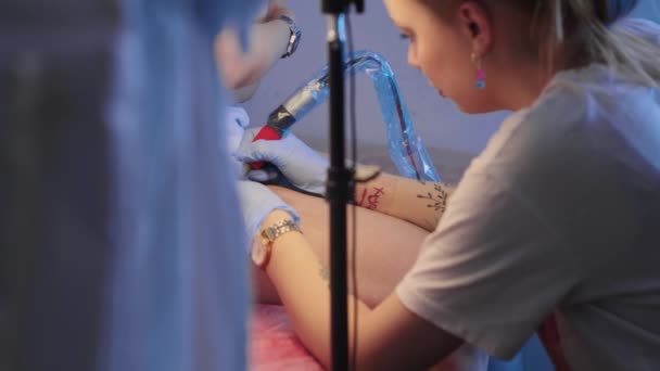 Tattoo session - tattoo master drawing an outlines of tattoo on the leg — Stock Video