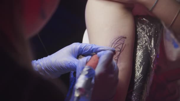 Tatuering session - kvinna att få en svart abstrakt ansikte tatuering — Stockvideo