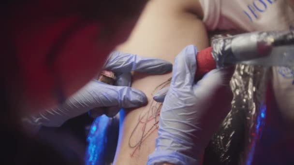 Τατουάζ συνεδρία - γυναίκα να πάρει μια αφηρημένη τατουάζ πρόσωπο στο χέρι της — Αρχείο Βίντεο