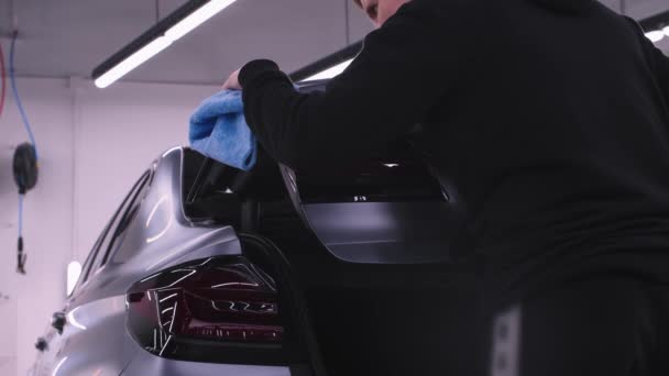 Auto detailing - man polishing a trunk lid of a grey car — Stock Video