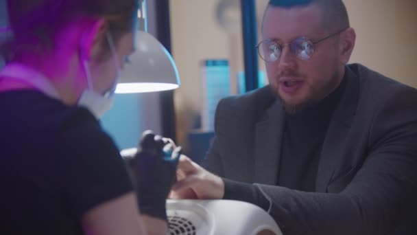 Mężczyzna manicure - biznesmen siedzi na manicure sesji w salonie i rozmawia z mistrzem — Wideo stockowe