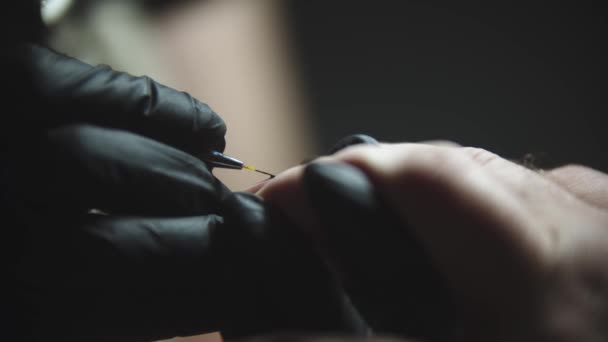 Male manicure - the man client doing a minimalistic black design on his nails by the master in the studio — Stock Video