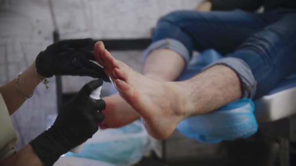 Pedicure procedure - the master disinfecting feet of her client after a salt bath — Stock Video