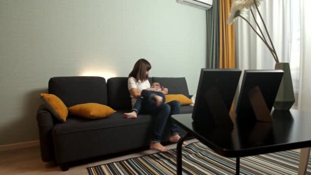 Glückliche Familie - Mutter spielt mit ihrem kleinen Sohn auf der Couch — Stockvideo