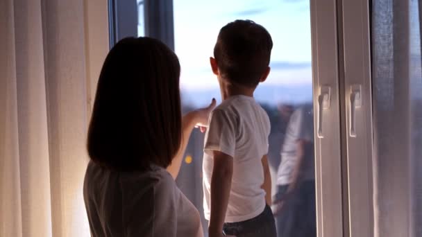 Η μητέρα και ο γιος της κοιτάζουν τους δρόμους πίσω από το παράθυρο. — Αρχείο Βίντεο
