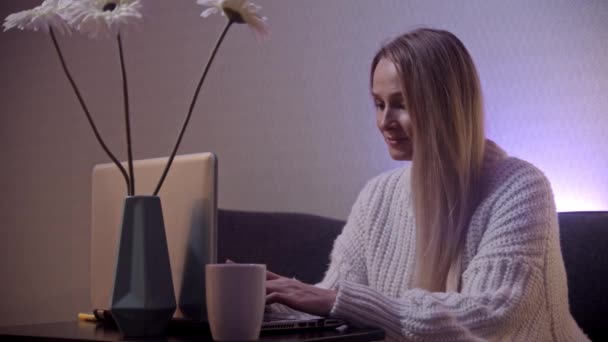 Una donna d'affari bionda che lavora presso il computer portatile e utilizza il suo telefono - lavoro freelance — Video Stock