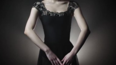 Siyah elbiseli genç bayan balerin içeride dans ediyor.