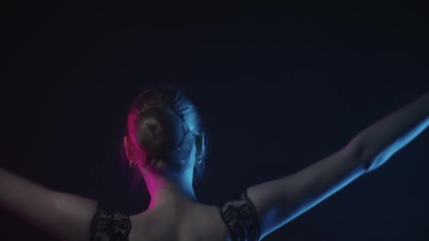 Ung kvinna ballerina värma upp i svart studio i neon belysning — Stockvideo