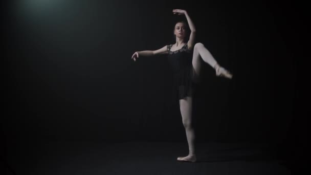 穿着黑色衣服的年轻而优雅的女芭蕾舞演员踮着脚尖慢慢地跳舞 — 图库视频影像