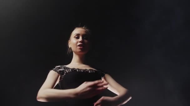 Young woman ballerina in black dress training her dancing in black studio — Stock Video