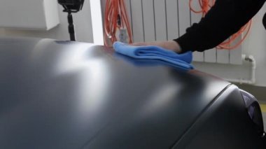 Otomatik temizleme - gri bir arabanın yüzeyini paçavrayla cilalayan bir kişi