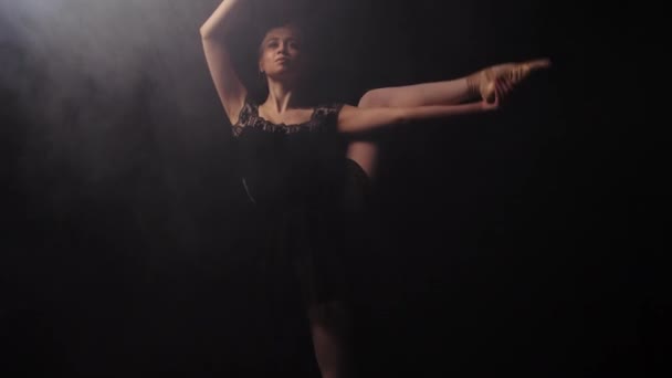 Красива балерина в чорній сукні, виконуючи свій танець на сцені — стокове відео