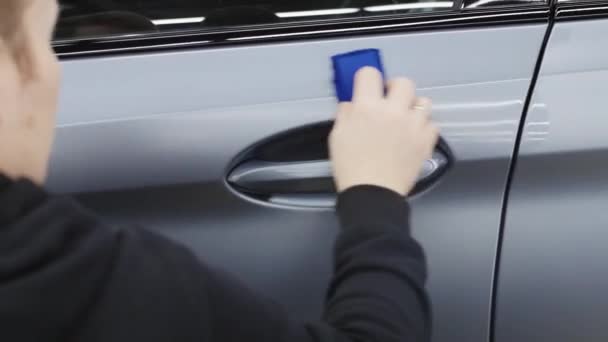 Automatikus részletezés - egy személy, aki ronggyal fényesíti a szürke autó ajtaját — Stock videók