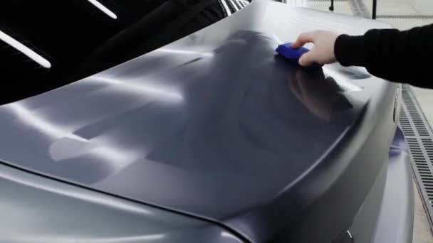Automatikus részletezés - egy férfi munkás polírozás felületén szürke autó szivaccsal — Stock videók