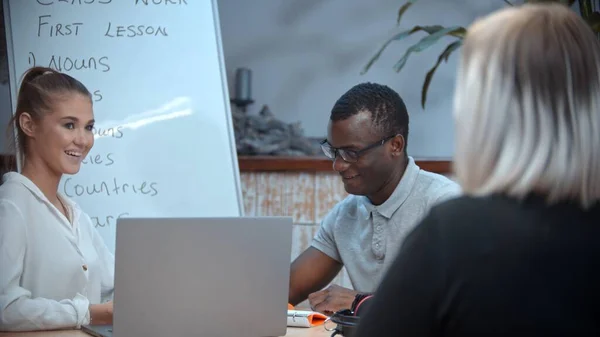 Una mujer blanca y un hombre negro con una lección de inglés — Foto de Stock