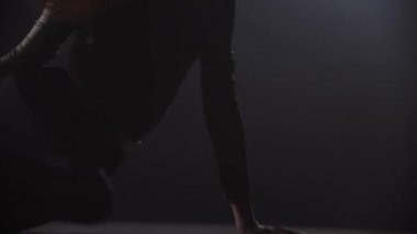 Karanlık dumanlı stüdyoda dans eden çekici bir kadın.