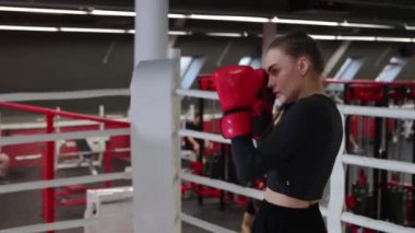 Genç ve güzel bir kadın boks antrenmanını spor salonunda yapıyor.