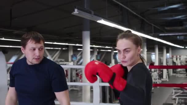 Young pretty woman training her boxing on the ring with trainer — Stock Video