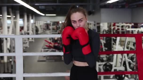 Молодая женщина тренирует свой бокс на ринге в спортзале — стоковое видео