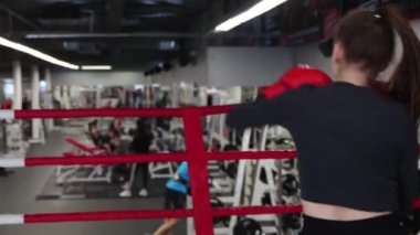 Genç bir kadın yumruklarını geliştirir. Gölge boksu.