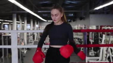 Dövüşçü kadın boks eldivenlerini giyer ve dövüşmeye hazırlanır.