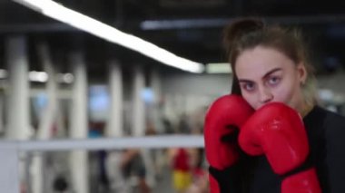 Genç ve çekici bir kadın ringde boks antrenmanı yapıyor.