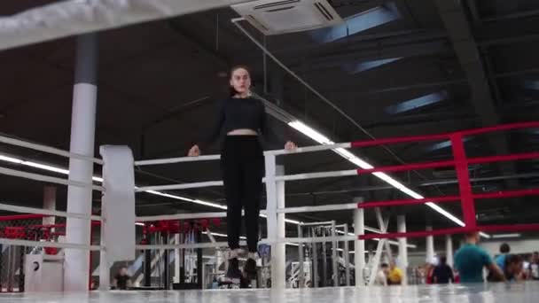 Mladá žena skákání přes provaz na boxerském kroužku — Stock video