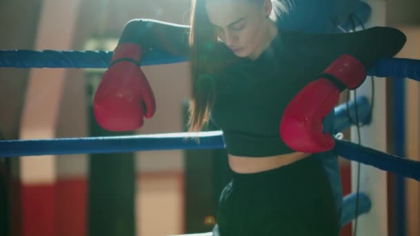 Uzun saçlı çekici bir genç kadın boks ringinde dinleniyor. — Stok video