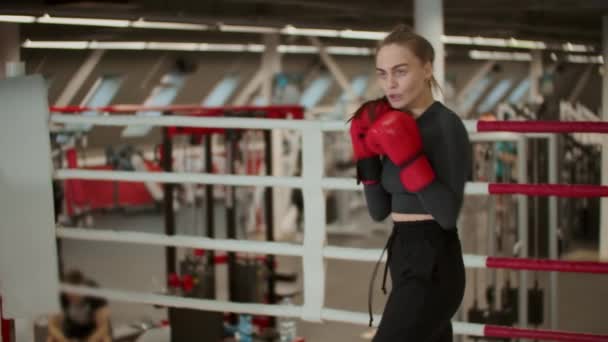 Привлекательная молодая женщина с длинными волосами тренирует свой боксерский удар - теневой бокс — стоковое видео