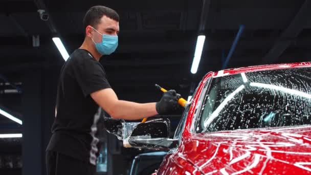 汽车细部- -用小刷子在汽车上使用清洁剂泡沫的人 — 图库视频影像