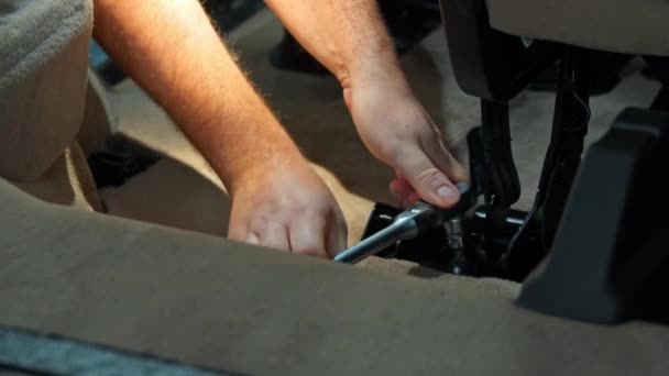 Αυτόματη λεπτομέρεια - άνθρωπος εργαζόμενος αποβιδώνει καρέκλα στο αυτοκίνητο με ένα κλειδί — Αρχείο Βίντεο