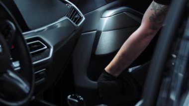 Araba yıkama servisi. Bir adam arabayı içeriden temizliyor.